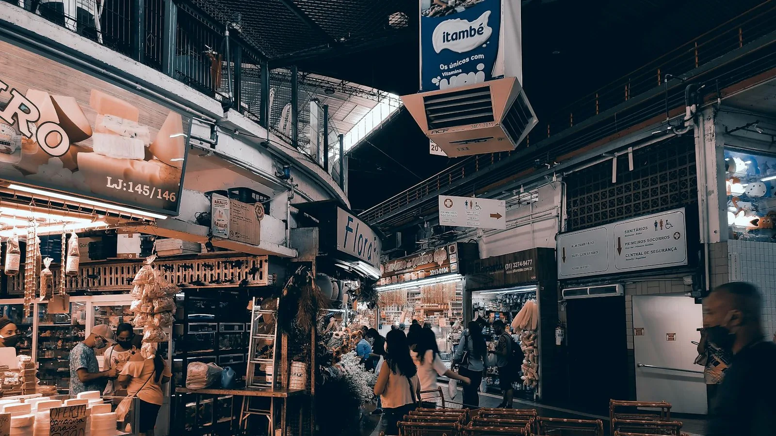 Vibrant indoor market filled with shoppers, food stalls, and lighting. Captures urban market vibe.