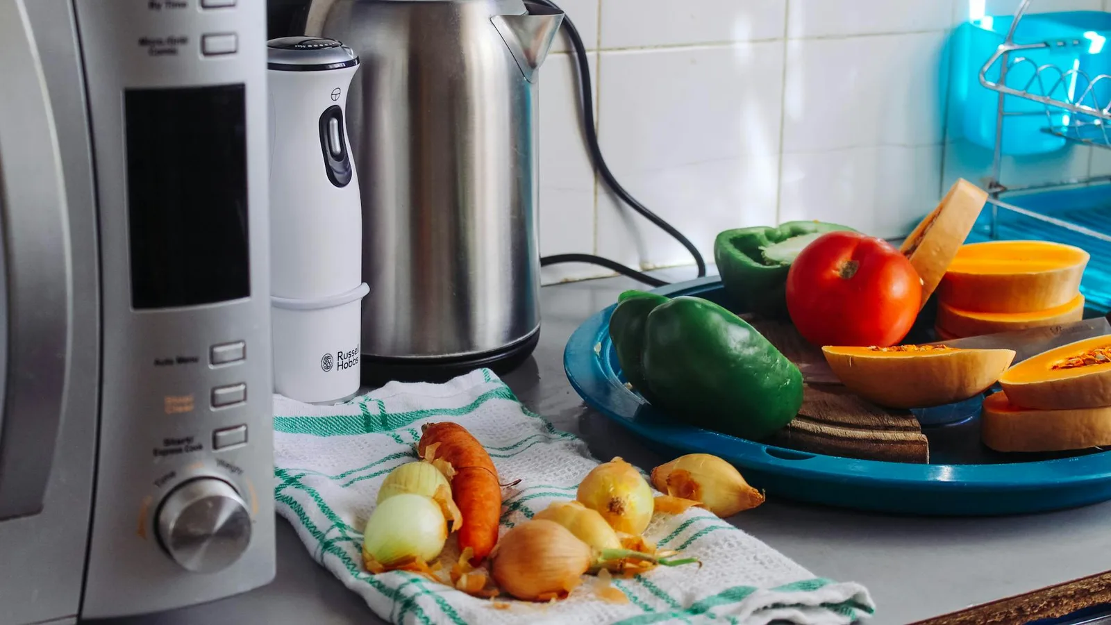 A modern home kitchen counter displaying fresh vegetables and appliances, ideal for healthy cooking.
