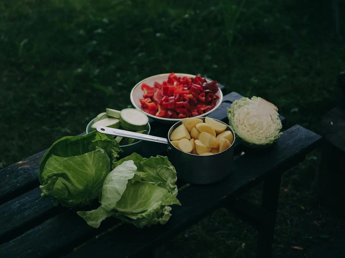 Freshly chopped vegetables on an outdoor table, perfect for a healthy meal.