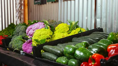Vibrant variety of vegetables including bell peppers, zucchini, and cauliflower on display.