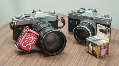 Two vintage Canon cameras with CineStill film on a wooden table, perfect for retro photography enthusiasts.
