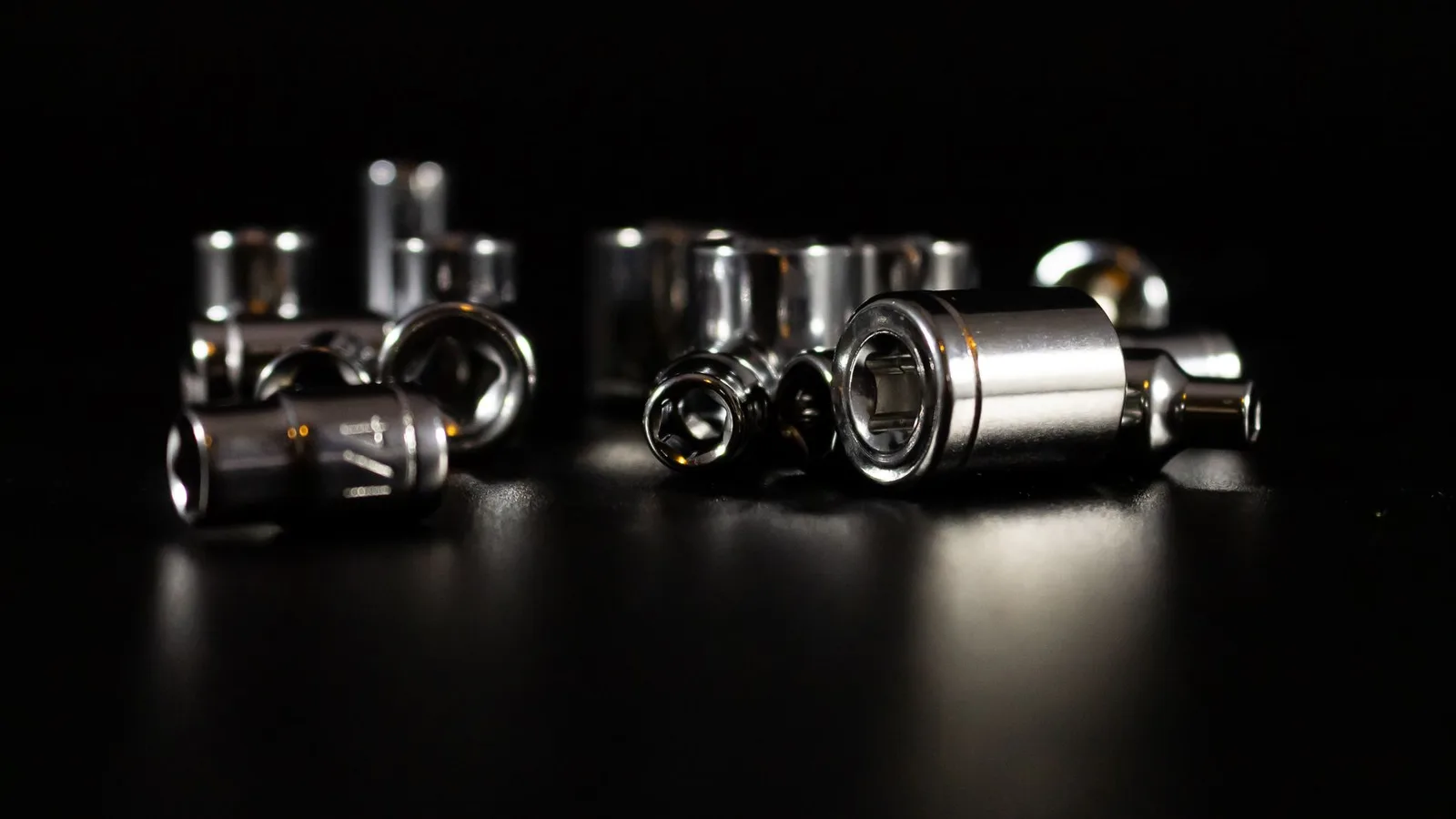Detailed view of chrome metallic socket tools against a dark background showcasing precision and craftsmanship.